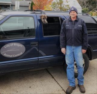 Man standing next to vehicle with dog